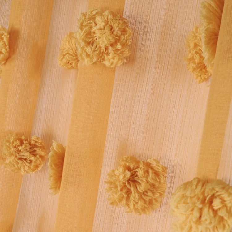 Visillo con pompones bordados